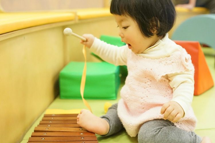 Cute baby girl playing xylophone at home