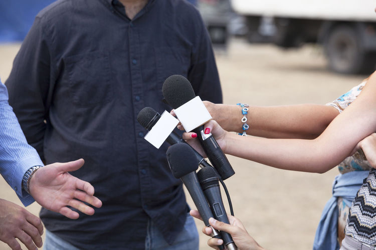 Cropped image of journalists interviewing man