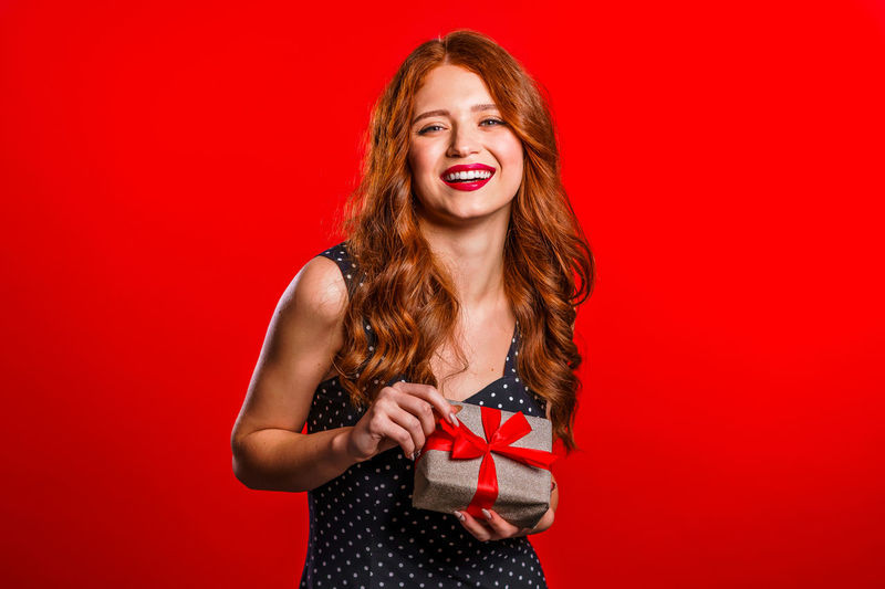 Portrait of a beautiful young woman against red background