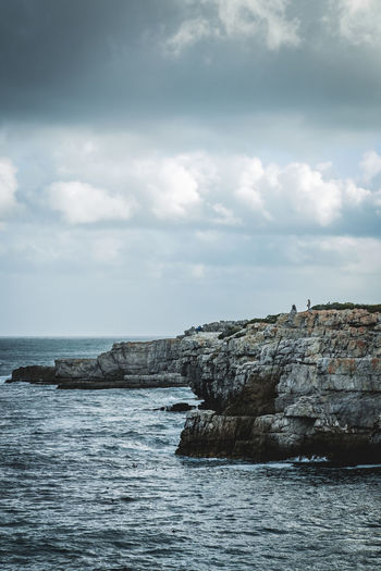Rocks by sea against sky