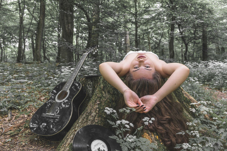 Portrait of young woman lying down in forest