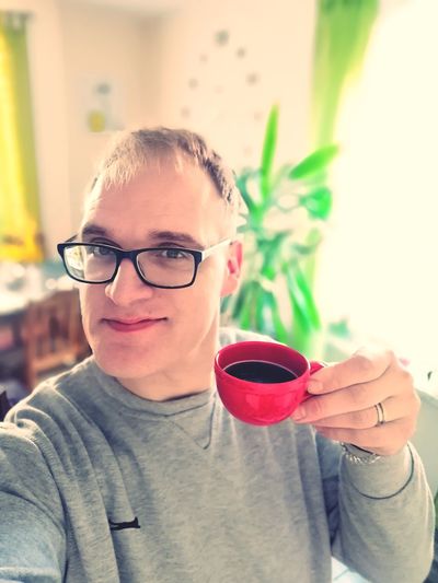 Portrait of smiling man having coffee at home