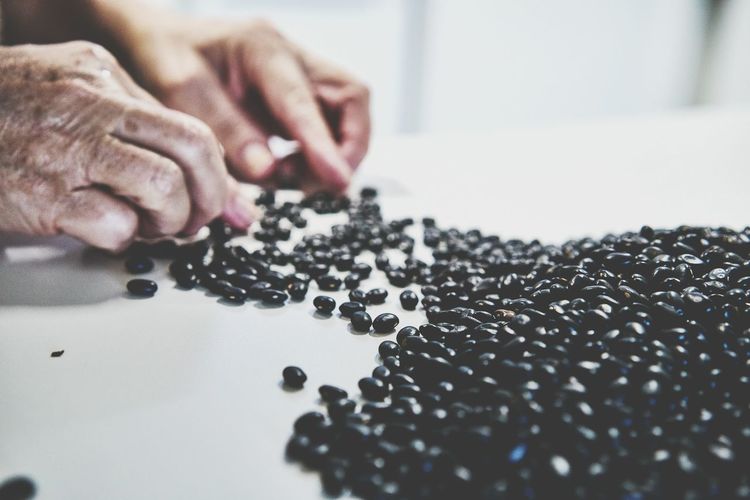 Close-up of hand separating black beans