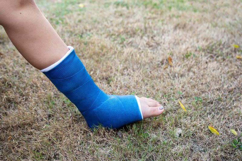 Low section of woman leg with bandage outdoors