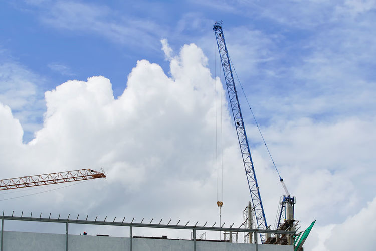 Low angle view of crane against sky