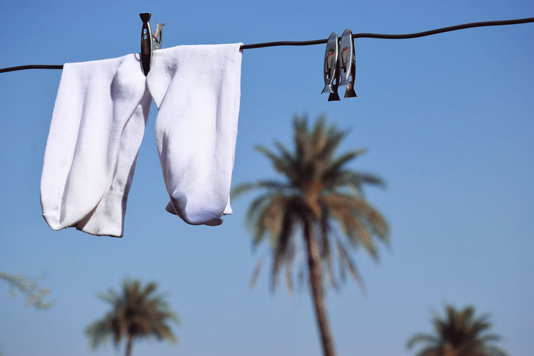 White socks hung on wire, blue sky in the background