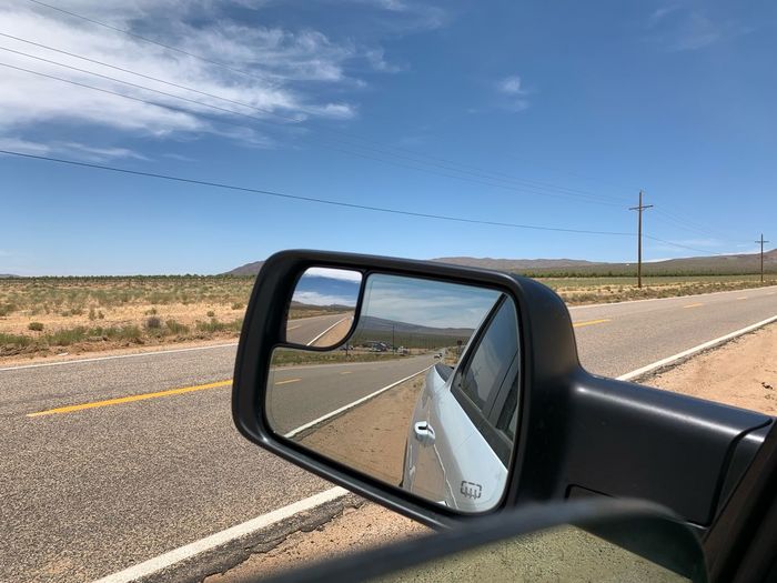 Side-view mirror of car on road