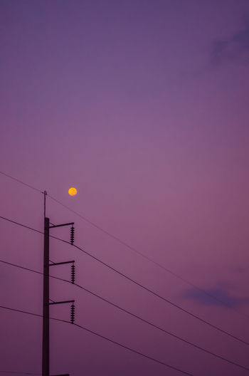 Low angle view of silhouette cables against sky during sunset
