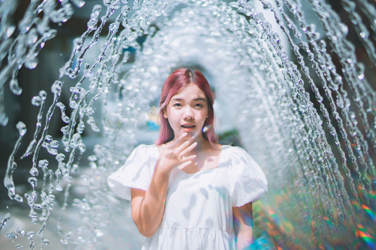 Portrait of young woman standing in water