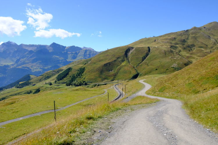 Road leading towards mountains against sky