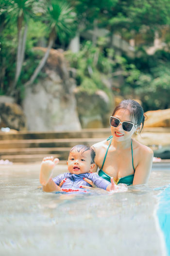 Portrait of mother with baby in swimming pool