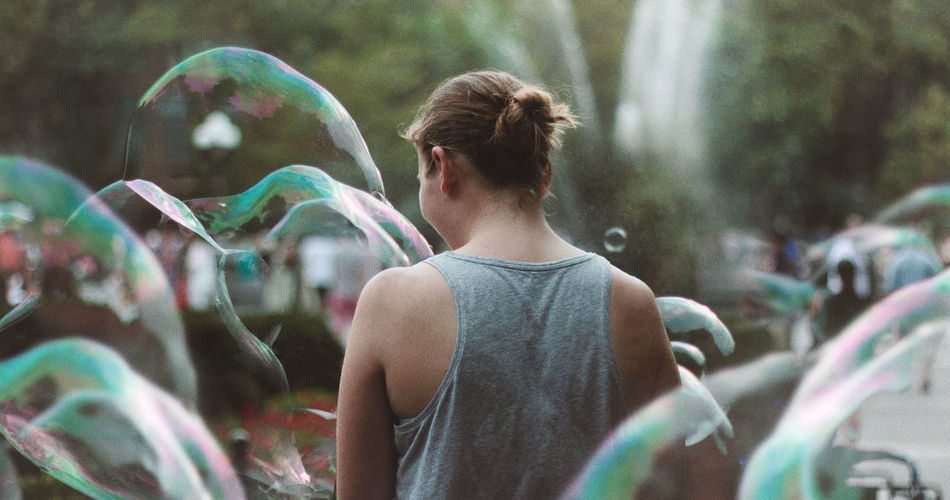 Rear view of woman with bubbles in park