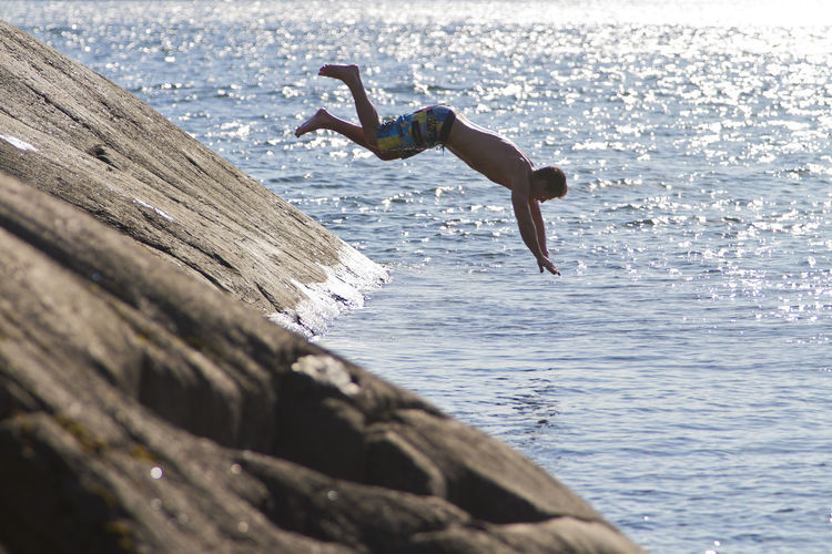 Side view of man jumping on beach