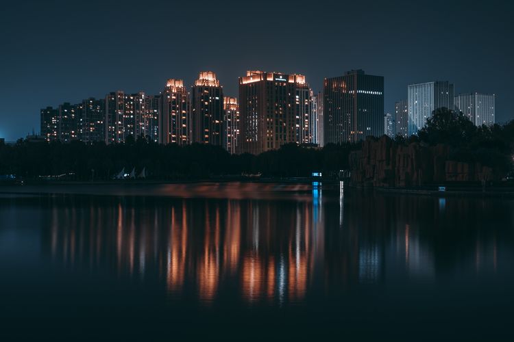 Illuminated buildings against sky at night