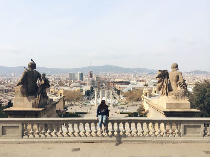 Woman sitting on railing at museu nacional d art de catalunya
