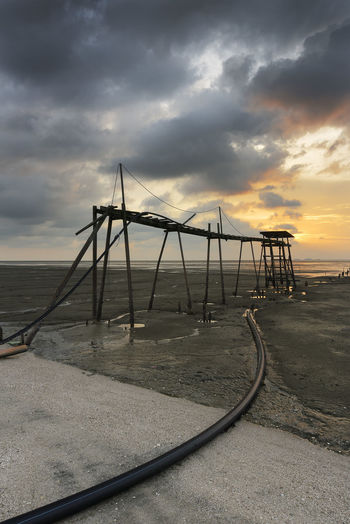 Built structure on beach at sunset