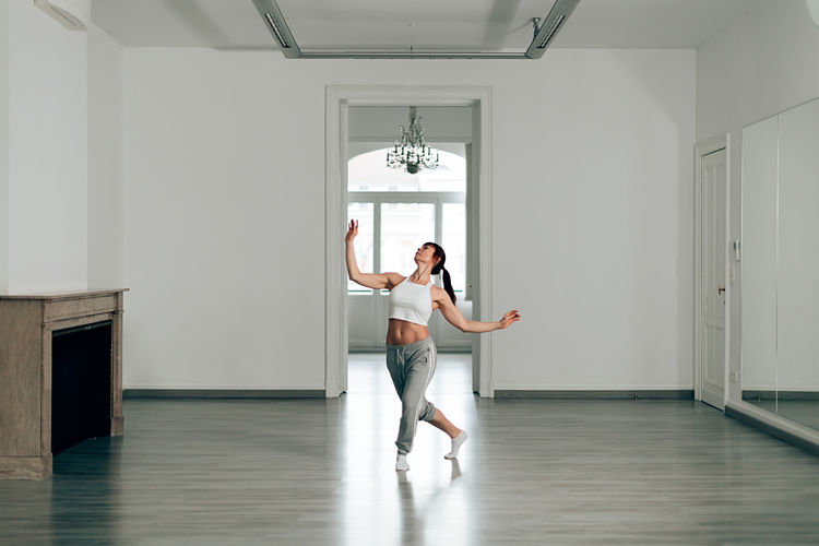 Woman elegantly dances alone at the dance school