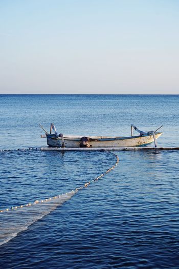 Side view of boat in sea against clear sky