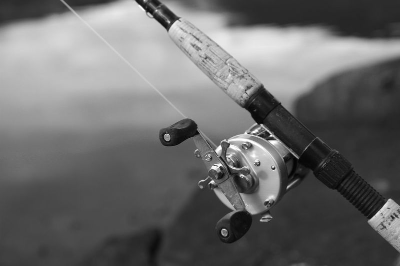 Close-up of fishing reel against sea