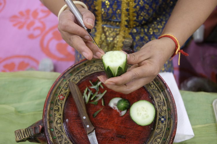 Cropped hands of woman carving on food