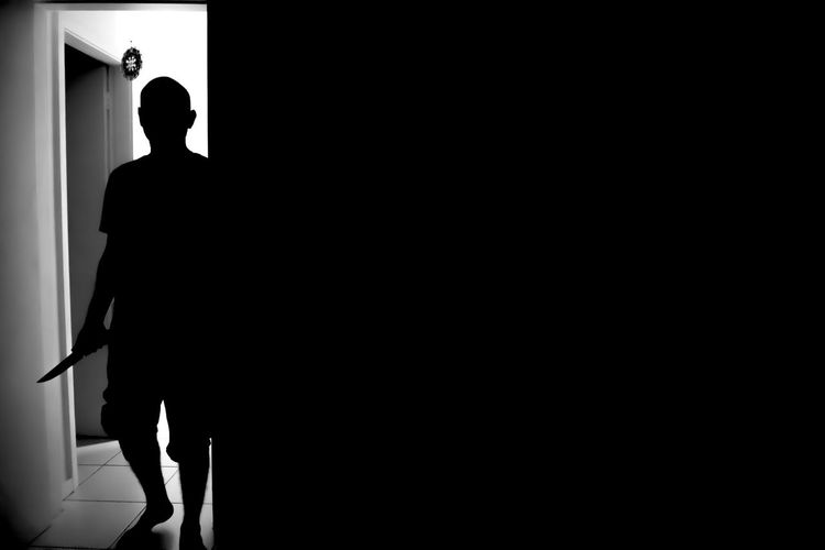 Silhouette killer walking in darkroom at home