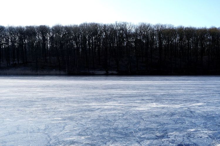 Frozen lake against sky during winter
