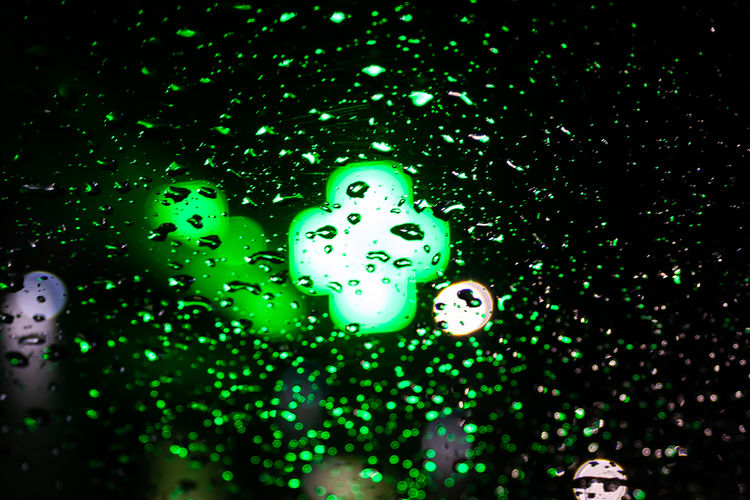 Close-up of water drops on illuminated lights