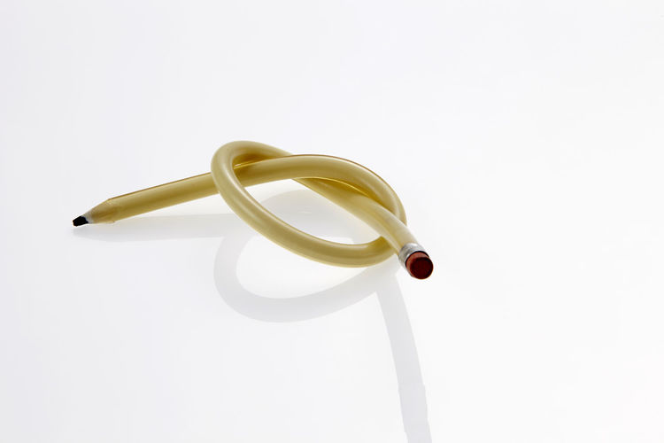 Close-up of knotted pencil against white background