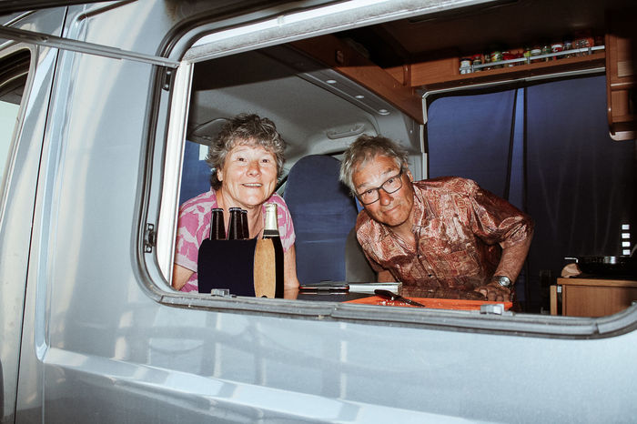 Portrait of senior couple in motor home seen through window