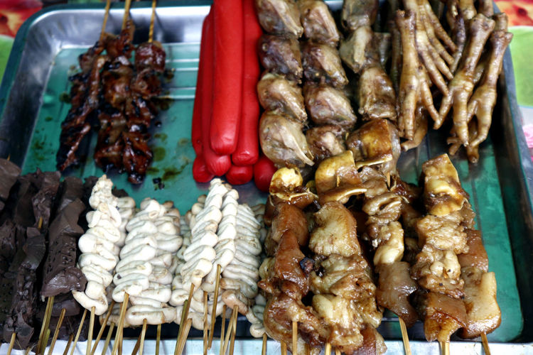 Assorted chicken and pork innards and hotdog in barbecue sticks sold as street food