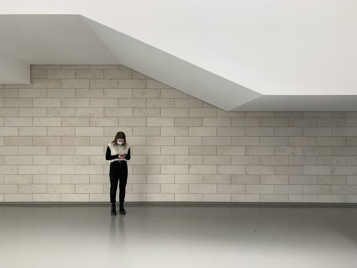 Minimalist interior with lonely girl browsing smartphone