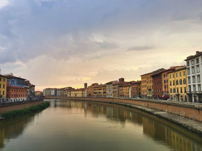 Canal amidst buildings against sky during sunset