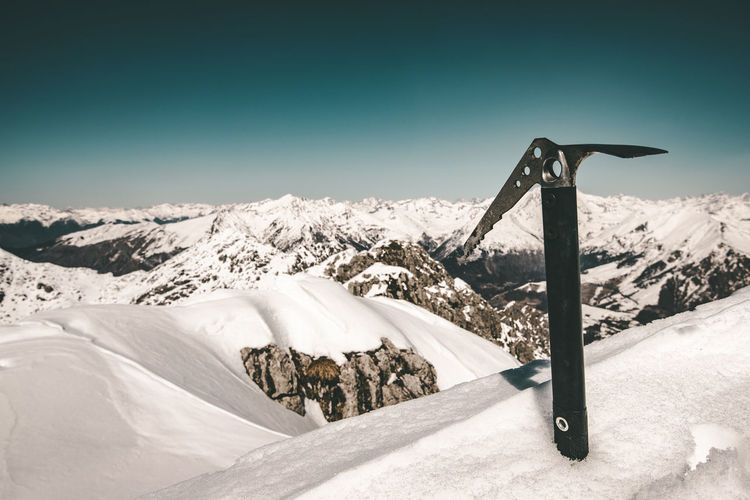 Ice ax in the snow on italian alps mountain range concepts about travel lifestyle and wanderlust