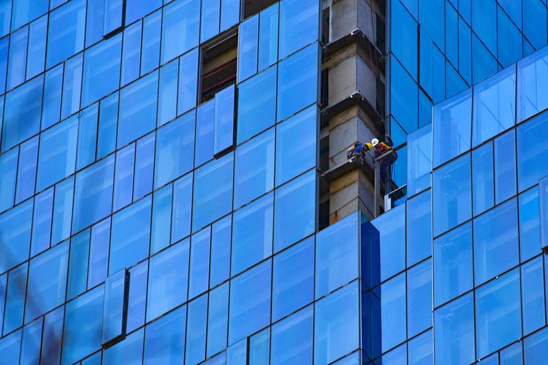 Low angle view of worker repairing office building