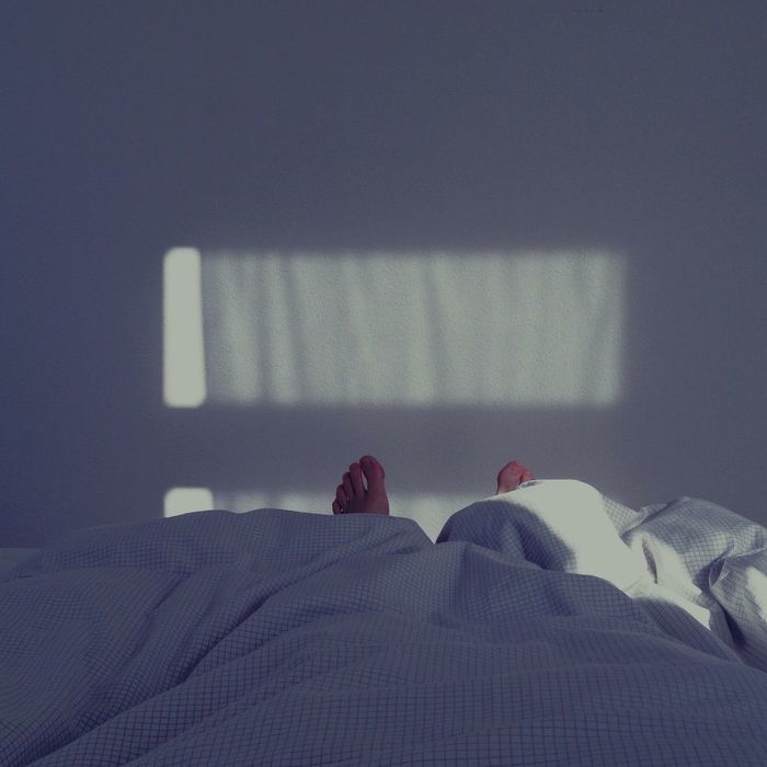 Low section of person lying in bed