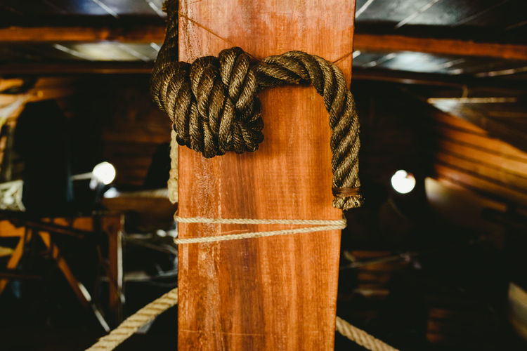 Close-up of rope tied up on wood