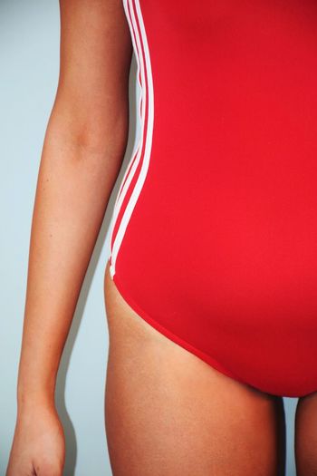 Midsection of woman wearing red swimsuit