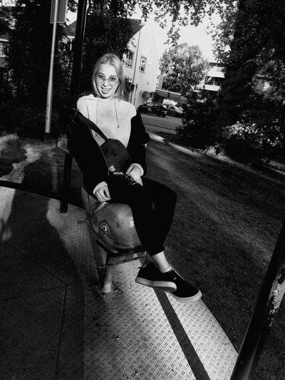 Portrait of woman sitting on footpath