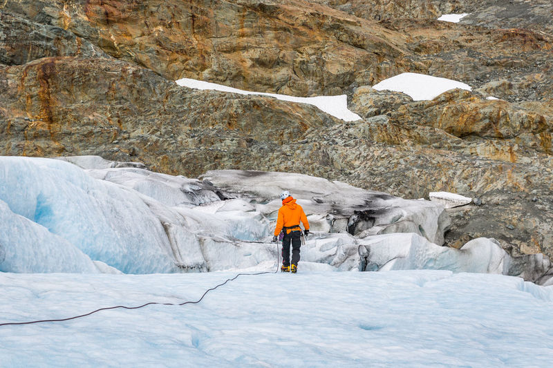 Rear view of man standing on glacier