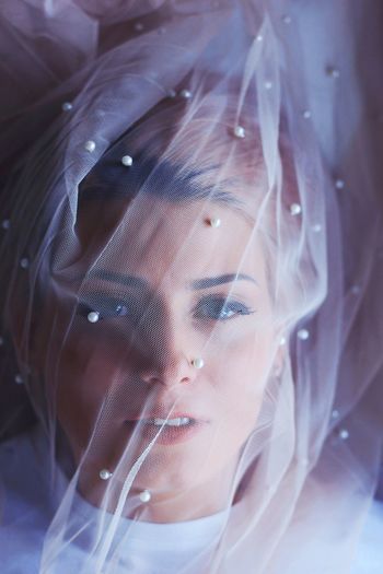 Close-up portrait of young woman covered with veil