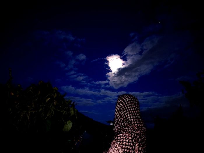 Low section of woman against sky at night