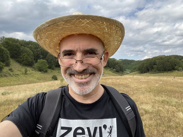 Portrait of smiling man wearing hat against sky