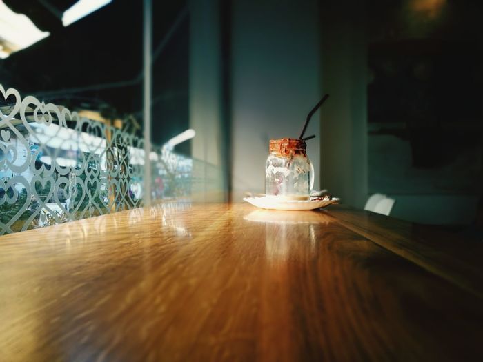 Surface level view of wooden table with empty mason jar at cafe