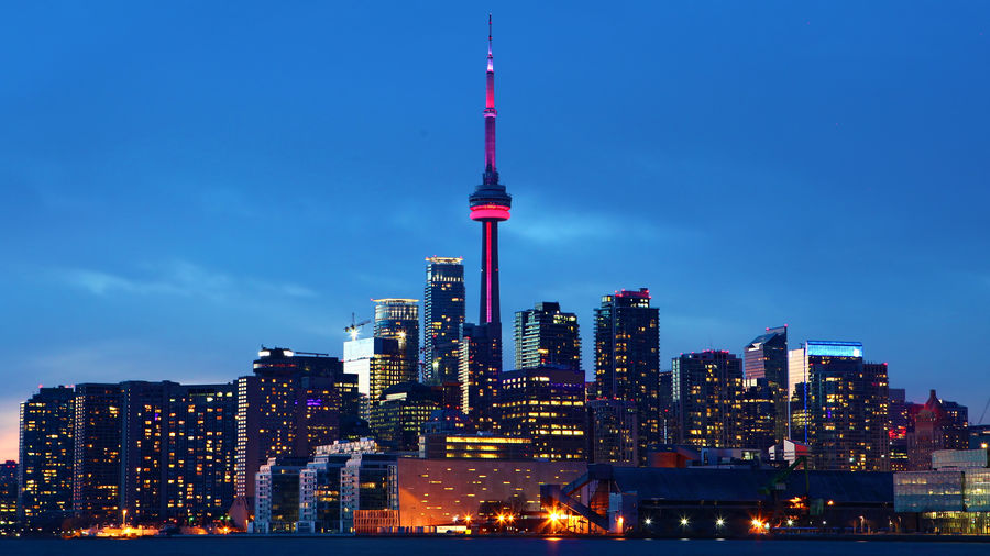 Illuminated buildings in city against sky
