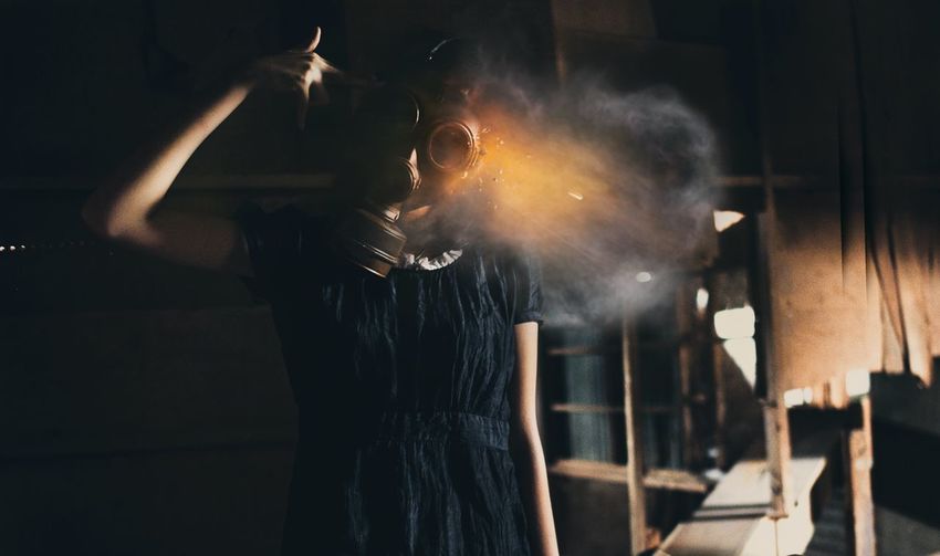 Woman wearing gas mask in abandoned building