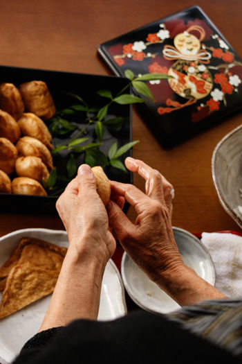 Cropped hand of person preparing food on table.