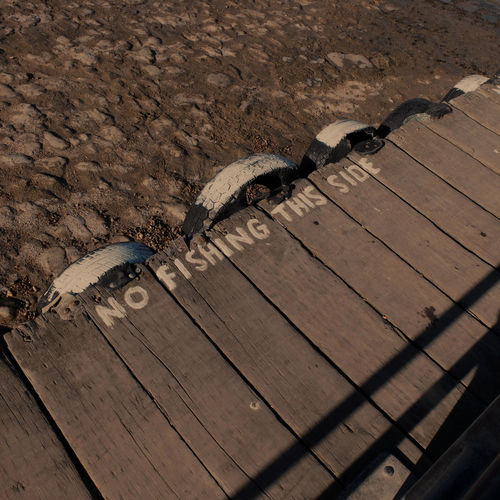 High angle view of information sign on pier at beach