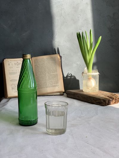 Close-up of glass vase on table against wall