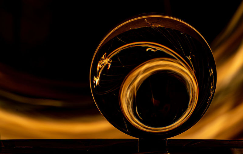 Close-up of crystal ball against illuminated background