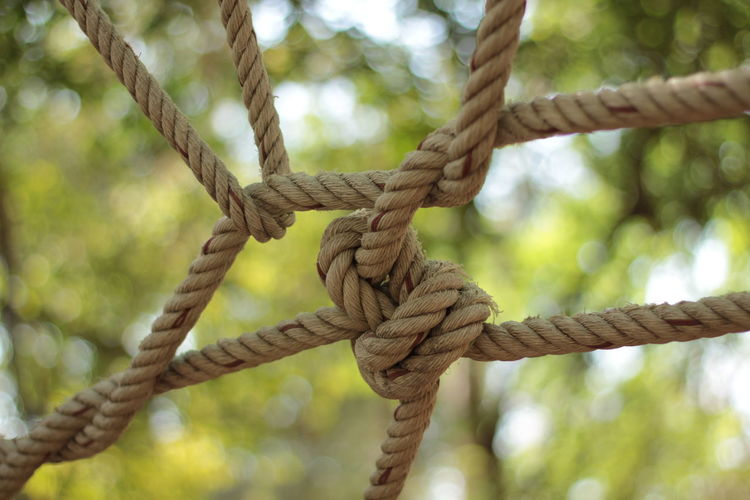 Close-up of rope tied to chain